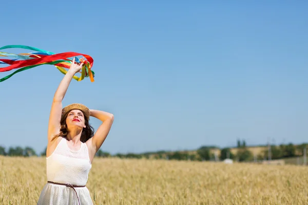 Happy girl holding colorful ribbons — ストック写真