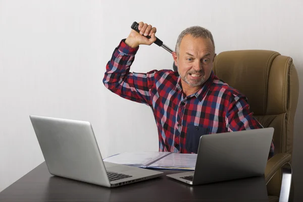 Angry man crashing laptop