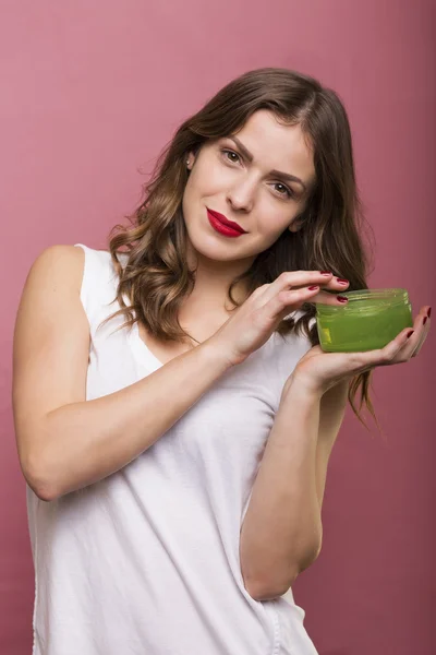 Mulher com uma garrafa de creme — Fotografia de Stock