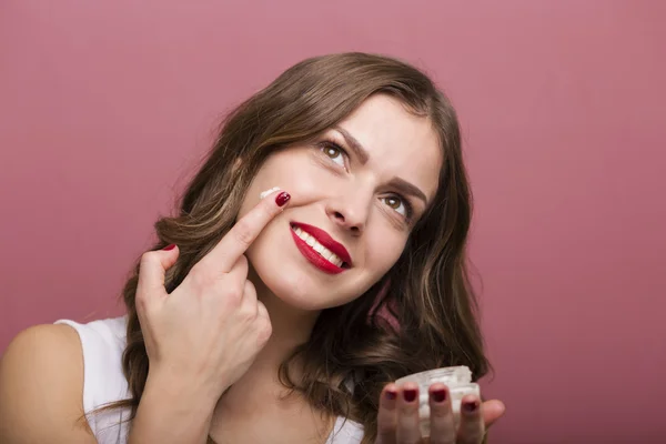 Femme avec une bouteille de crème — Photo