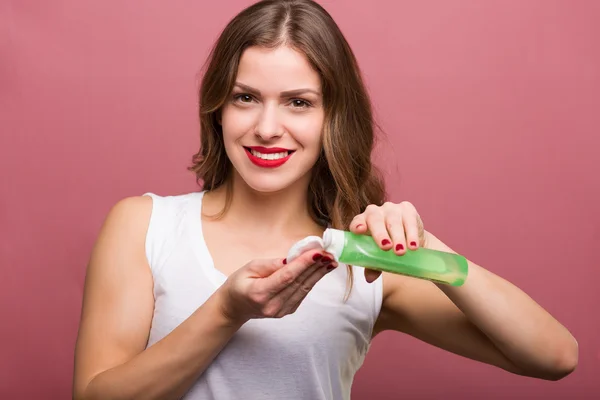 Woman holding a lotion and a cotton pad — Stock Photo, Image