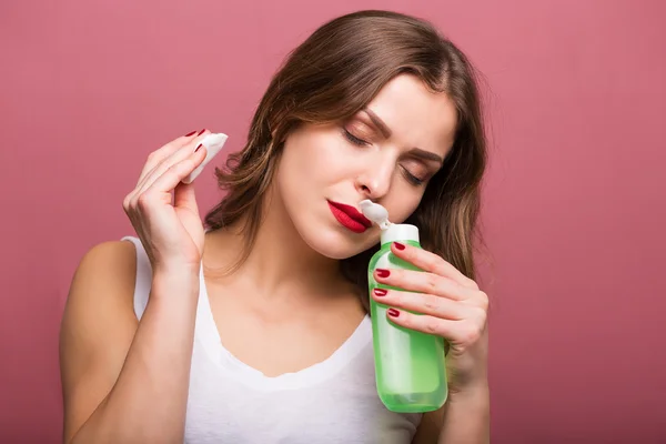 Woman holding a lotion and a cotton pad — Stock Photo, Image