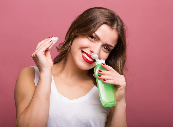 Woman holding a lotion and a cotton pad — Stock Photo, Image