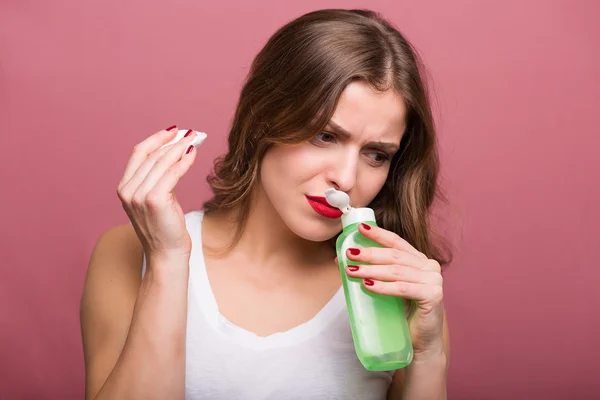 Mujer sosteniendo una loción y una compresa de algodón —  Fotos de Stock