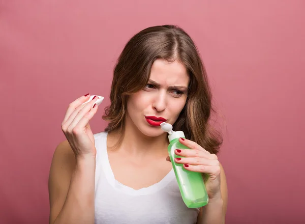 Woman holding a lotion and a cotton pad — Stock Photo, Image