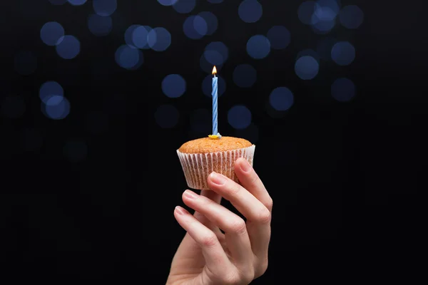 Magdalena de cumpleaños con una vela en la mano de la mujer — Foto de Stock