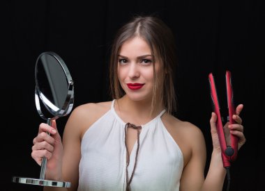 Bir ayna ve düz saç demir kadın ile