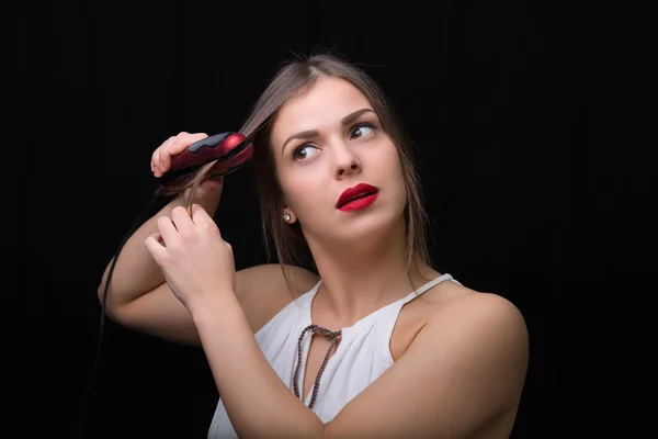 Жінка з плоским залізом для волосся — стокове фото