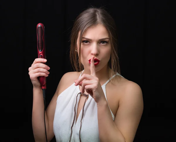 Mujer con una plancha de pelo plano — Foto de Stock