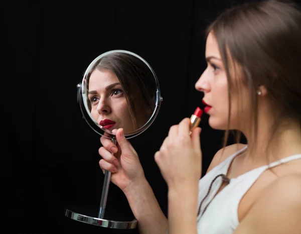Женщина с зеркалом и красной помадой — стоковое фото