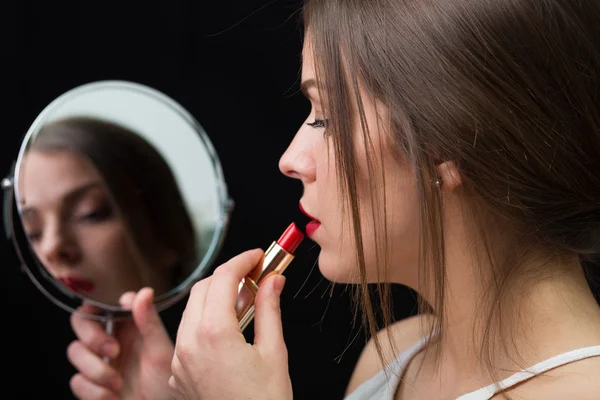 Mujer con espejo y lápiz labial rojo — Foto de Stock