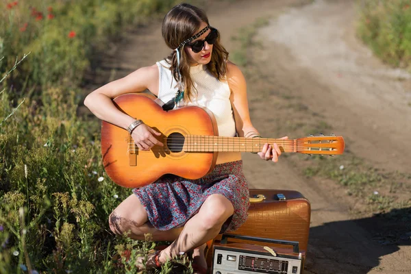 Beautiful woman with a suitcase and a guitar — Stock Photo, Image