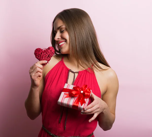 Vrouw in rode jurk met een geschenkdoos — Stockfoto