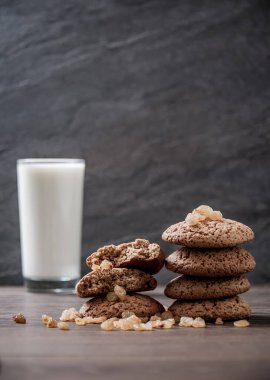 Tahta masada bir bardak süt ve yulaf ezmeli kurabiye.