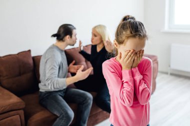 Kızgın ebeveynler evde kavga ederken hayal kırıklığına uğramış küçük bir kız depresyonda. Anne ve babalar tarafından incitilen küçük kızı üzmek ya da boşanmak, çocuk ve aile içi çatışma kavramı.