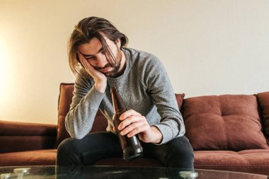  Alkol bağımlılığı, genç yaşta. Beyaz erkek alkolü bırakamıyor, elinde bira şişesi olan erkek. Yalnızlık, depresyon ve alkolizm 