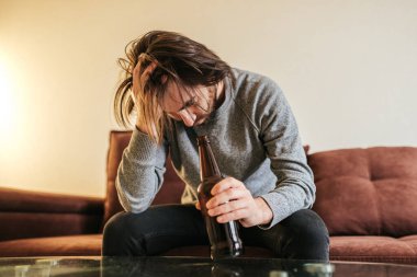  Alkol bağımlılığı, genç yaşta. Beyaz erkek alkolü bırakamıyor, elinde bira şişesi olan erkek. Yalnızlık, depresyon ve alkolizm 
