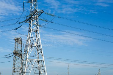 Akşamları yüksek voltajlı elektrik direği ve şanzıman hatları. Enerji endüstrisi, enerji tasarrufu