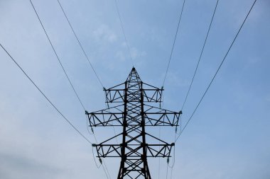 Akşamları yüksek voltajlı elektrik direği ve şanzıman hatları. Enerji endüstrisi, enerji tasarrufu