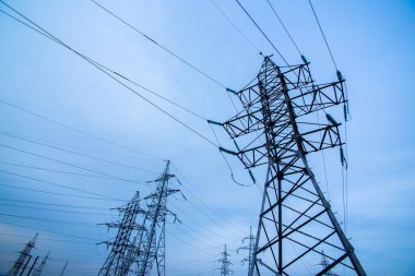 Mavi gökyüzü arka planında elektrik direkleri. Güç ve enerji. Enerji korunumu. Enerji endüstrisi, enerji tasarrufu