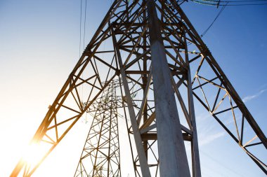 Endüstriyel arazi. Siluet Yüksek voltajlı elektrik kulesi gün batımı saatinde ve gökyüzü günbatımı arkaplanında.