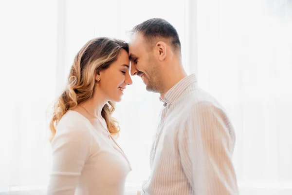 side view of a Loving young couple relaxing at home and kissing. Image of optimistic smiling young loving couple