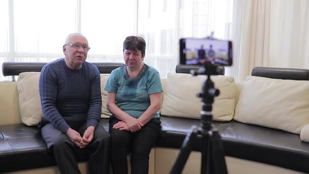 행복 한 노인 커플 이 아늑 한 거실에서 비디오 블로그를 녹음 하고 있습니다.. — 비디오