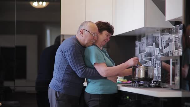 Šťastný starší pár objetí v kuchyni domu. — Stock video