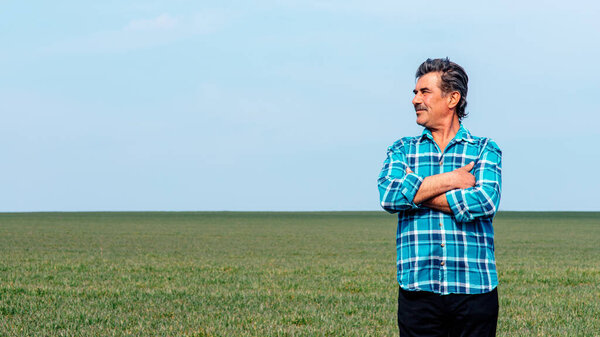 Experienced and confident farmer stands on his field