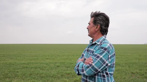 Zkušený a sebevědomý farmář stojí na svém poli. — Stock video