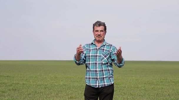 Uma visão frontal de um Portrait agricultor proprietário feliz no campo, o homem fala na frente da câmera — Vídeo de Stock