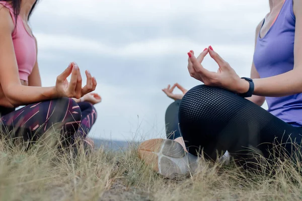 Nahaufnahme von zwei schönen, sportlich fitten jungen Frauen, die im Freien meditieren oder atmen, — Stockfoto