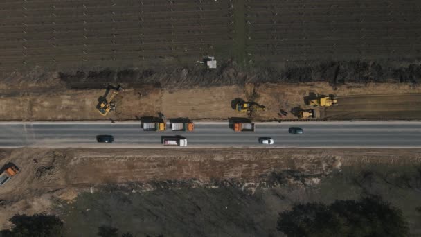 Graafmachine graven grond en laad het in dump truck op de weg. — Stockvideo