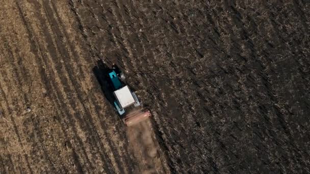 Luchtfoto van landbouwtrekkers die land bewerken eggen de grond op de vruchtbare akkers — Stockvideo