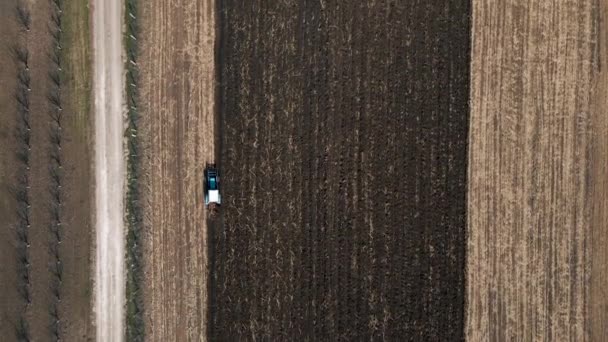 Flygfoto av en traktor som drar en plog på ett åkerfält — Stockvideo
