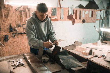 Kalaycı demirci atölyesinde çekiç kullanıyor..