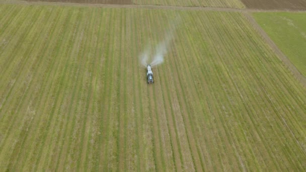 Antenn utsikt över en jordbrukstraktor som kör besprutning på fruktträdgård äpple frukt trädgård med spruta — Stockvideo