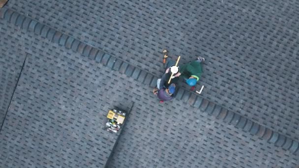 Вид с воздуха на двух рабочих на крыше, устанавливающих железный дымоход. — стоковое видео