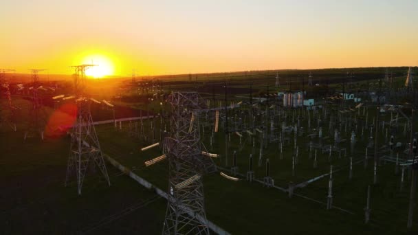 Yüksek voltajlı elektrik hatlarının havadan görüntüsü. Gün batımında elektrik dağıtım istasyonu. — Stok video