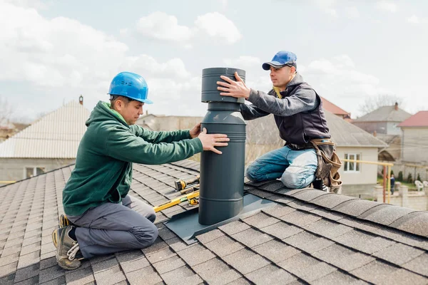 Zwei professionelle Handwerker stehen auf dem Dach und messen Schornstein — Stockfoto