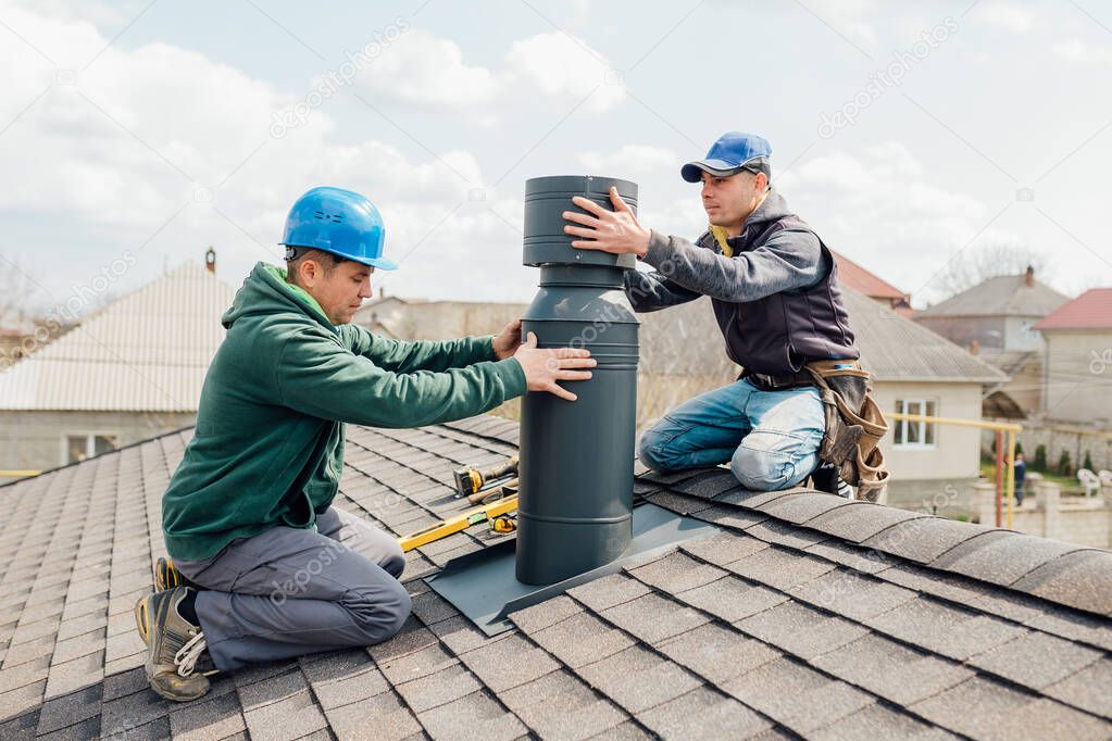 two Professional workmens standing roof top and measuring chimney