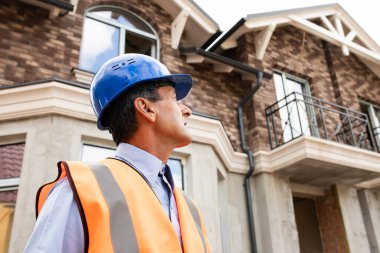 İnşaat alanında kıdemli işçi. İnşaat işçisi güvenlik kaskı takıyor.