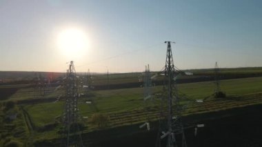Gün batımında yüksek voltajlı elektrik hatlarının havadan görüntüsü. Elektrik dağıtım istasyonu.