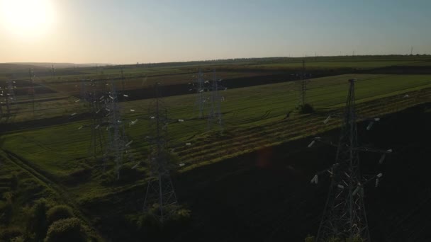 日没時に架空高圧送電線を支える送電塔上空を飛行する無人機. — ストック動画