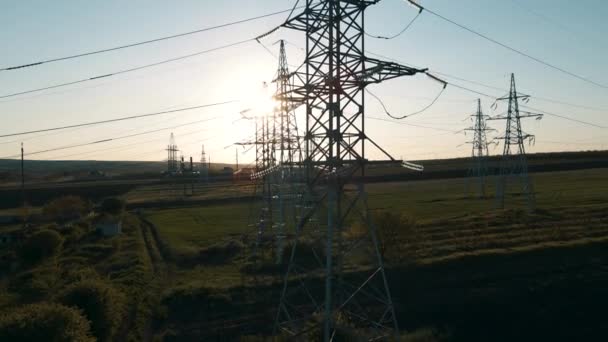 Günbatımında elektrik direklerinin hava görüntüsü ve yüksek voltajlı elektrik hattı — Stok video