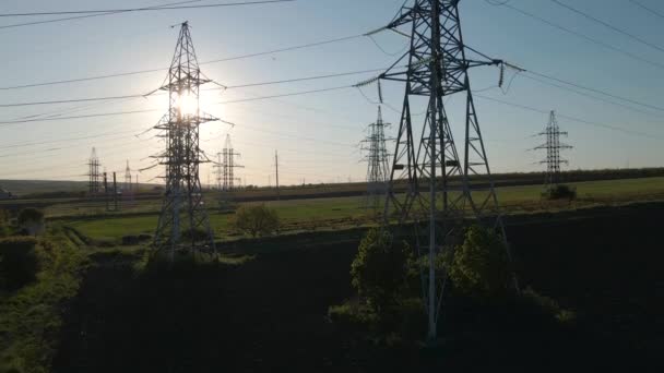 Vista aérea de los pilones eléctricos y la línea eléctrica de alto voltaje al atardecer — Vídeos de Stock