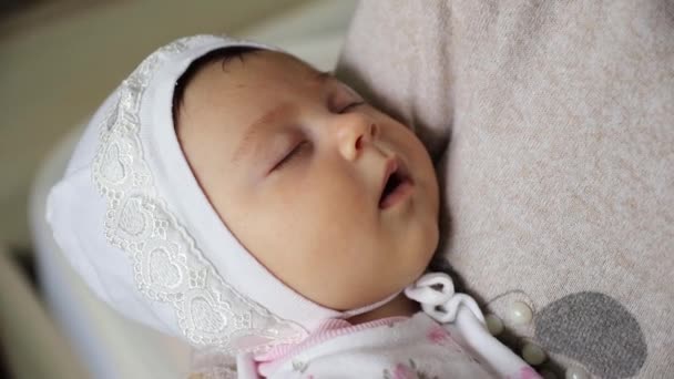 Κοντινό πλάνο της νεαρής μητέρας που κρατάει το νεογέννητο κοιμισμένο μωρό της — Αρχείο Βίντεο