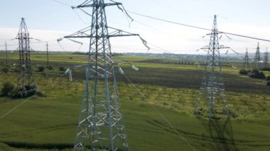 İnsansız hava aracı tarım arazisi üzerinde uçuyor ve güzel gökyüzüne karşı yüksek voltajlı elektrik pilonu..