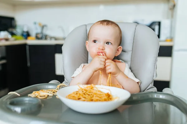 Ragazzino mangiare spaghetti guardare affamato e sugo di pasta — Foto Stock