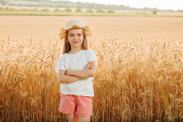 Bedårande glad liten flicka med hatt i vetefältet — Stockfoto